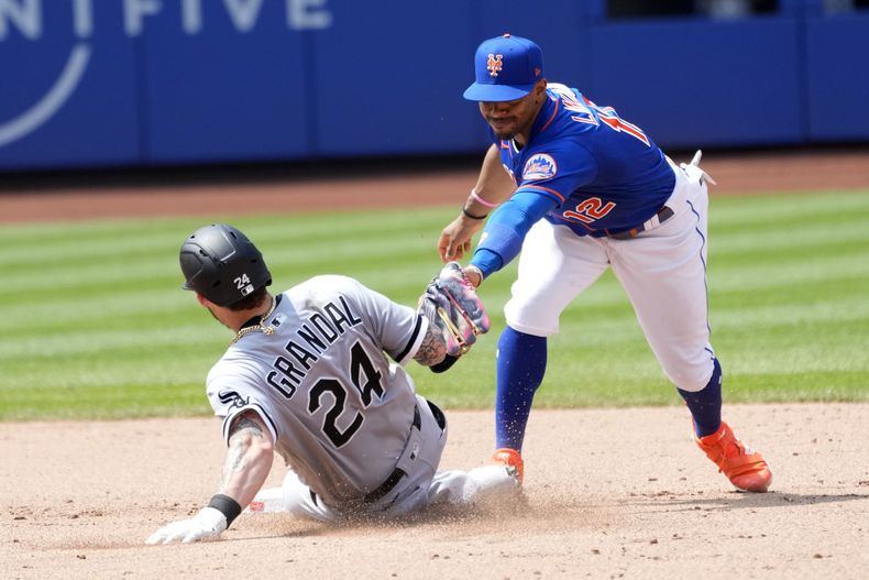 Yasmani Grandal de los Medias Blancas de Chicago se desliza en la segunda base ante el torpedero Francisco Lindor de los Mets de Nueva York, el jueves 20 de julio de 2023. (AP Foto/Mary Altaffer)