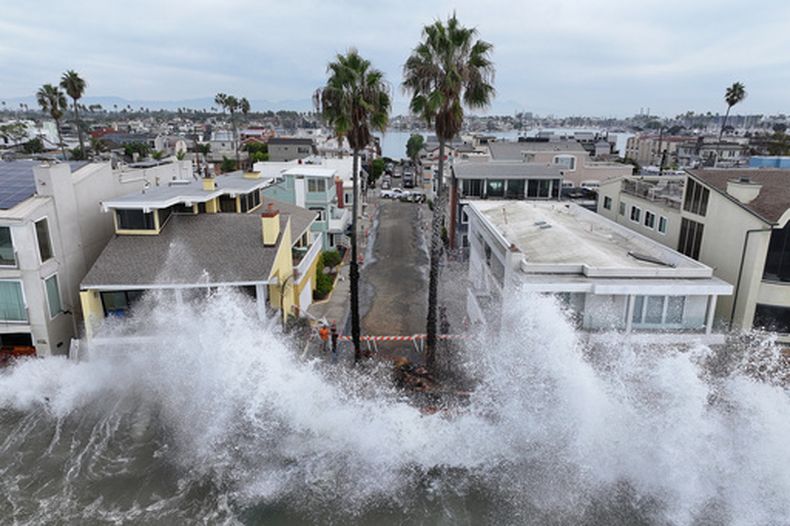 Las olas chocan contra un pasaje frente a unas viviendas en Long Beach, California, el 10 de octubre del 2026. (AP foto/William Liang)