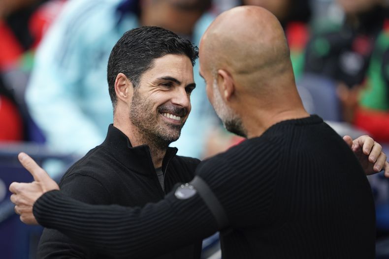 El técnico del Arsenal Mikel Arteta saluda al entrenador del Manchester City Pep Guardiola antes del encuentro de la Liga Premier el domingo 22 de septiembre del 2024. (AP Foto/Dave Thompson)