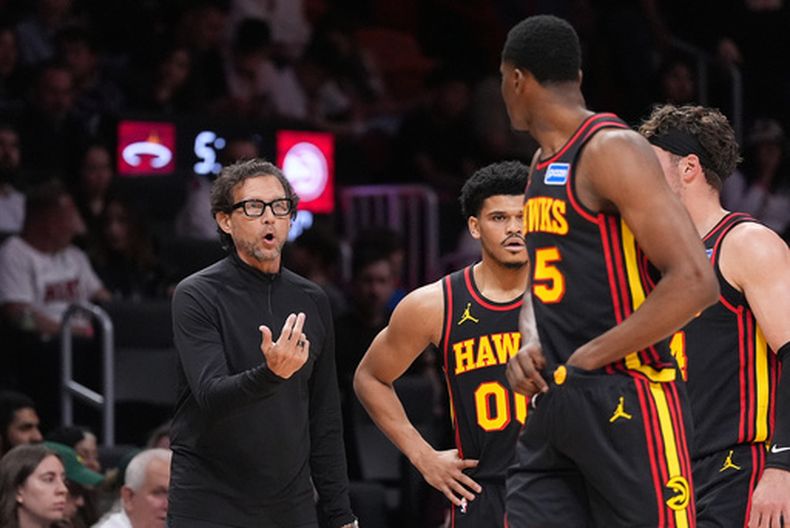 Quin Snyder, entrenador de los Hawks de Atlanta, habla con Dyson Daniels (5) en el partido ante el Heat de Miami, el domingo 12 de abril de 2026 (AP Foto/Rebecca Blackwell)