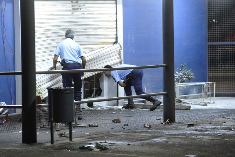 Dos guardias civiles observan una tienda que fue saqueada en C&oacute;rdoba, Argentina, el martes 3 de diciembre de 2013, por una huelga de la polic&iacute;a para pedir un aumento salarial. (Foto AP/Veronica Maggi,La Voz del Interior)