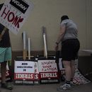 Dos manifestantes toman carteles en un mitin en el exterior de los estudios de Paramount Pictures en Los Ángeles, el 21 de septiembre de 2023. (AP Foto/Jae C. Hong)