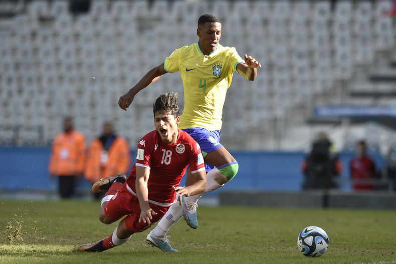 Mohamed Dhaoui de Túnez, a la izquierda, el derribado por Robert Renan de Brasil durante los octavos de final del Mundial Sub20 en el estadio Diego Maradona de La Plata, Argentina, miércoles 31 mayo, 2023. (AP Foto/Gustavo Garello)