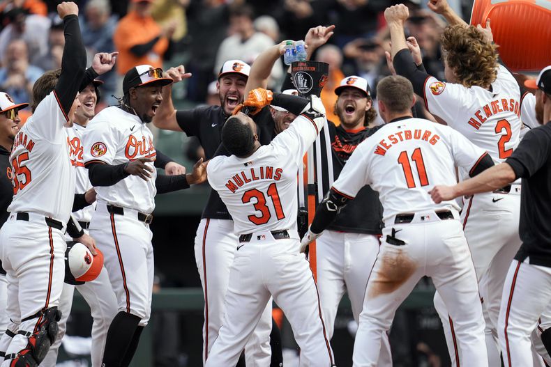 Cedric Mullins, de los Orioles de Baltimore, bebe del Homer Hydration Station mientras celebra con sus compañeros de equipo después de batear un jonrón de dos carreras y dejar tendidos a los Mellizos de Minnesota en la novena entrada del juego de béisbol, el miércoles 17 de abril de 2024, en Baltimore. Los Orioles ganaron 4-2. (AP Foto/Jess Rapfogel)