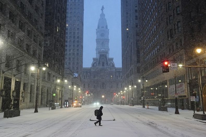 Una persona cruza una calle durante la tormenta invernal en Filadelfia, el domingo 25 de enero de 2026. (Foto AP/Matt Rourke)