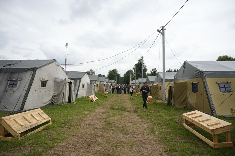 Periodistas examinan un campamento del ejército bielorruso cerca de la aldea de Tsel, a unos 90 kilómetros (unas 55 millas) al sureste de Minsk, Bielorrusia, el viernes 7 de julio de 2023. (AP Foto/Alexander Zemlianichenko)