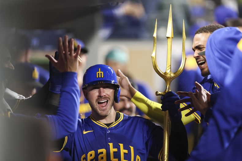 Mitch Garver, de los Marineros de Seattle, festeja en la cueva luego de conseguir un jonrón ante los Angelinos de Los Ángeles, el viernes 12 de septiembre de 2025 (AP Foto/Kevin Ng)