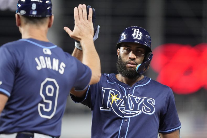 Amed Rosario, de los Rays de Tampa Bay, a la derecha, es felicitado después de conectar un sencillo contra los Marlins de Miami durante la novena entrada de un juego de béisbol el martes 4 de junio de 2024 en Miami. (AP Foto/Lynne Sladky)