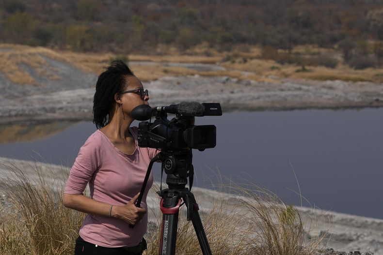 La periodista visual de la AP, Sebabatso Mosamo, de pie junto a su cámara en una asignación en Phalaborwa, Sudáfrica, el miércoles 3 de septiembre de 2025. (AP Foto/Themba Hadebe)