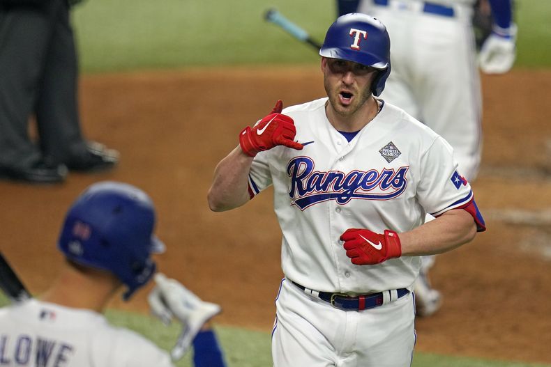 ARCHIVO - Mitch Garver, derecha, de los Rangers de Texas, celebra después de batear un cuadrangular en contra de los Diamondbacks de Arizona durante la quinta entrada del Juego 2 de la Serie Mundial, el sábado 28 de octubre de 2023, en Arlington, Texas. El domingo 24 de diciembre de 2023, los Marineros de Seattle reforzaron su plantilla al llegar a un acuerdo por dos años y 24 millones de dólares con el receptor agente libre Mitch Garver. (AP Foto/Julio Cortez, Archivo)
