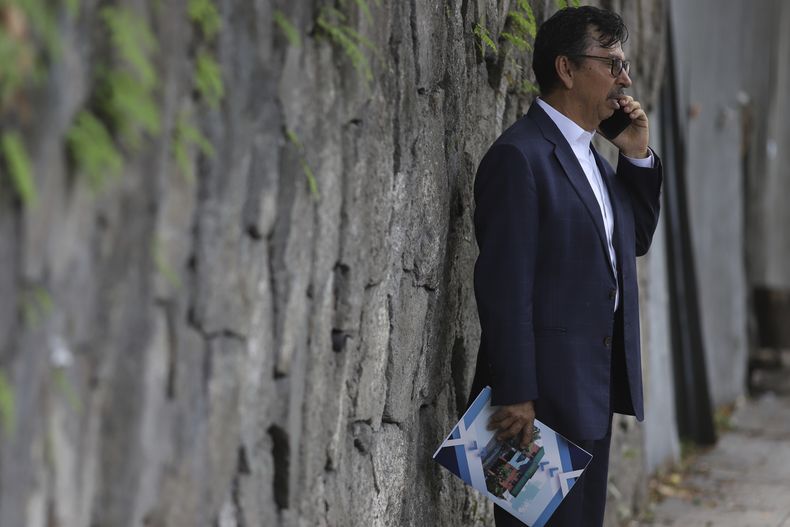 Jaime Quintanilla, abogado de Salvador Enrique Anaya, crítico del goibierno del presidente Nayib Bukele, habla en su celular afuera de un cuartel policial el martes 10 de junio de 2025 tras llegar para visitar a su cliente en San Salvador. Anaya fue detenido el 7 de junio por presunto lavado de dinero y de activos. (AP Foto/Salvador Meléndez)
