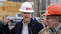 El primer ministro canadiense, Mark Carney, bromea sobre su casco con el presidente de Elmsdale Lumber Yard, Robin Wilber, en un evento de campaña en el aserradero, en Elmsdale, Nueva Escocia, el martes 25 de marzo de 2025. (Frank Gunn/The Canadian Press vía AP)