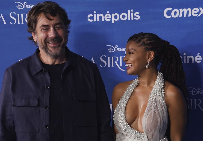 Los actores Halle Bailey, derecha, y Javier Bardem posan en la alfombra azul de la película La Sirenita en la Ciudad de México el 11 de mayo de 2023. (Foto AP/Marco Ugarte)