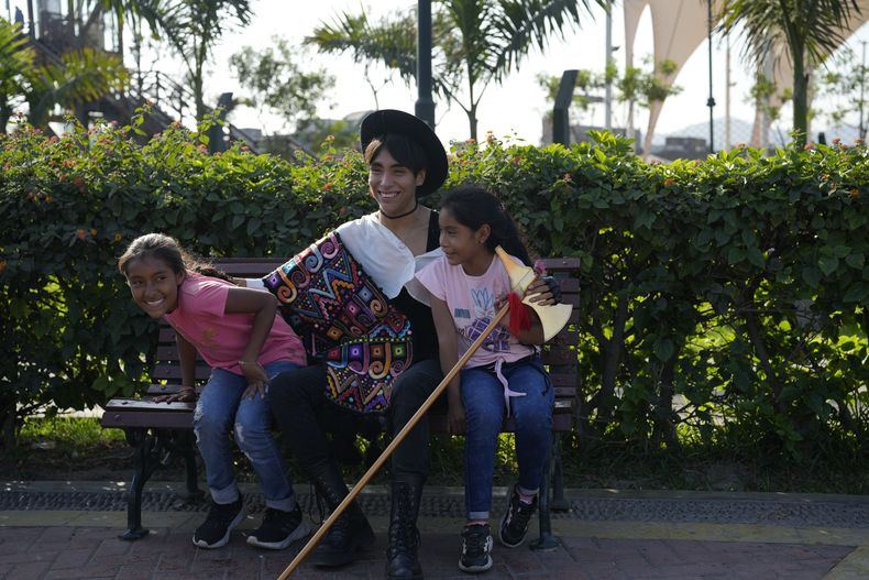 El músico peruano Lenin Tamayo bromea con niñas fans durante un receso de la grabación de un video en el centro de Lima, Perú, el jueves 3 de agosto de 2023. Con su fusión de K-pop y cultura andina, el músico de 23 años es conocido como creador del Q-pop o Quechua pop, con canciones en español y quechua. (Foto AP/Martin Mejia)