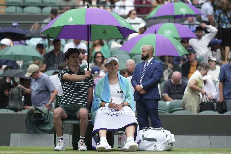 El checo Barbora Krejcikova descansa con una sombrilla durante el duelo de la tercera ronda ante la estadounidense Emma Navarro en Wimbledon el sábado 5 de julio del 2025. (AP Foto/Alastair Grant)