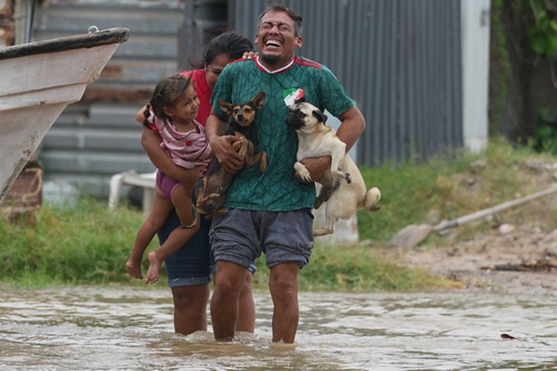 Tres personas evacúan su hogar mientras el huracán Polo se acerca a Puerto San Carlos, en el estado de Baja California Sur, México, el lunes 28 de septiembre de 2026. (Foto AP/Eduardo Verdugo)