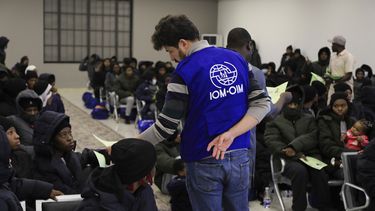 Un funcionario de la Organización Internacional de las Migraciones habla con migrantes nigerianos antes de ser deportados desde Trípoli, Libia, el 18 de marzo de 2025. (AP Foto/Yousef Murad)