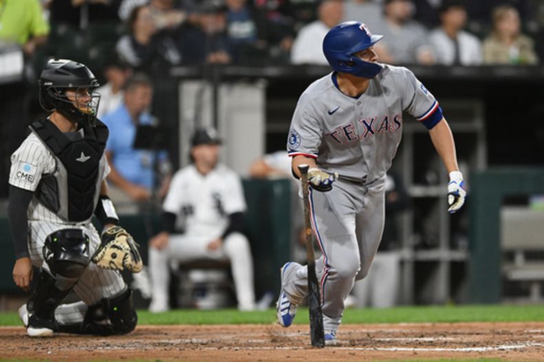 Corey Seager, derecha, de los Rangers de Texas, observa su doble productor de dos carreras durante la tercera entrada del juego de béisbol de Grandes Ligas ante los Medias Blancas de Chicago, el lunes 24 de agosto de 2026, en Chicago. (AP Foto/Paul Beaty)
