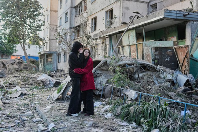 Dos personas se abrazan mientras observan el lugar donde un misil ruso impactó un edificio residencial, el martes 2 de junio de 2026, en Kiev, Ucrania. (AP Foto/Efrem Lukatsky)