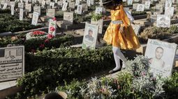 Una niña yemení visita las tumbas de hutíes durante el feriado de Eid al-Fitr, que pone fin al Ramadán, en Saná, Yemen, el 30 de marzo de 2025. (AP Foto/Osamah Abdulrahman)