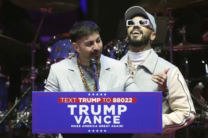 Anuel AA y Justin Quiles hablan antes de que el presidente electo Donald Trump llegue a un mitin previo a la 60ª toma de posesión presidencial, el domingo 19 de enero de 2025, en Washington. (Foto AP/Matt Rourke)