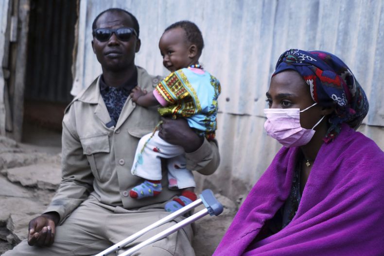 Chandera Weldesenbet, un ex combatiente de Etiopía, afuera de su casa con su hijito y su esposa Rahel Gebrekidan en Quiha, Tigray, Etiopía, el 14 de febrero del 2025. (AP foto/Amanuel Birhane)