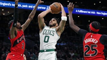 Jayson Tatum, de los Celtics de Boston, salta hacia la canasta entre Jalen McDaniels y Chris Boucher, de los Raptors de Toronto, el sábado 11 de noviembre de 2023 (AP Foto/Michael Dwyer)