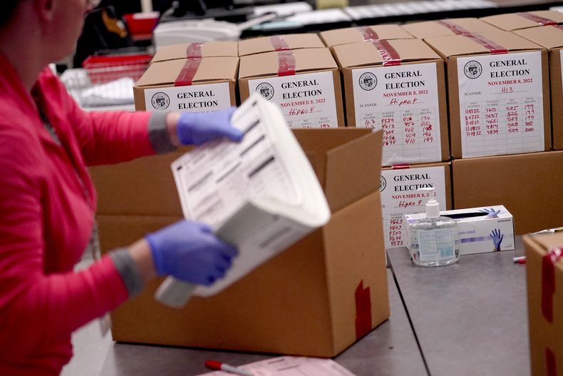 ARCHIVO - Un trabajador electoral empaqueta papeletas escrutadas en una oficina del condado de Maricopa, el miércoles 9 de noviembre de 2022, en Phoenix. (AP Foto/Matt York, Archivo)