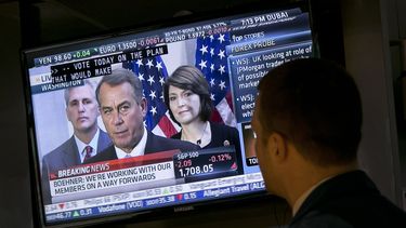 americateve | El especialista de la Bolsa de Nueva York, Frank Masiello ve una conferencia de prensa donde John Boehner, l&iacute;der de la C&aacute;mara de Representantes, informa sobre las discusiones fiscales en el Congreso, el martes 15 de octubre de 2013. (Foto AP