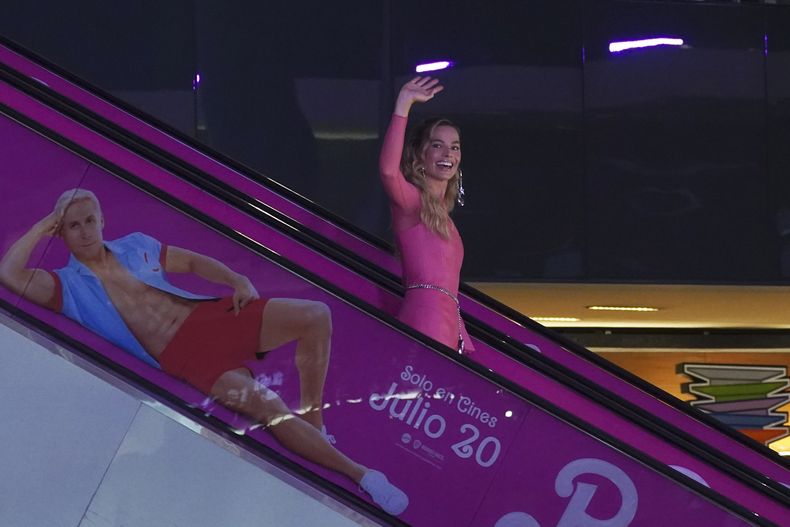 La actriz Margot Robbie desciende en una escalera eléctrica a la alfombra rosa de la película Barbie en la Ciudad de México el jueves 6 de julio de 2023. (Foto AP/Marco Ugarte)