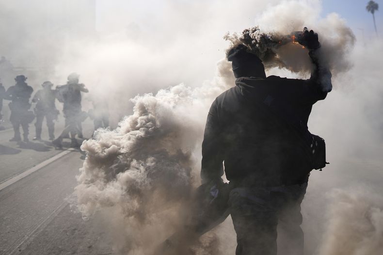 Un manifestante arroja una lata de gas lacrimógeno cerca del Centro de Detención Metropolitano, el domingo 8 de junio de 2025, en el centro de Los Ángeles. (AP Foto/Eric Thayer)