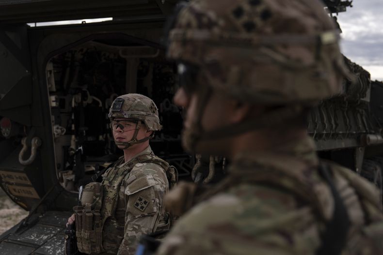 El sargento del ejército estadounidense Brenden Richards vigila la zona parado junto a un vehículo de combate Stryker, el 23 de julio de 2025, en Sunland Park, Nuevo México. (AP Foto/Jae C. Hong)