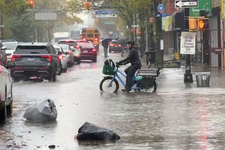Un ciclista atraviesa una inundación durante una tormenta en Nueva York, el jueves 30 de octubre de 2025. (AP Foto/David Martin)