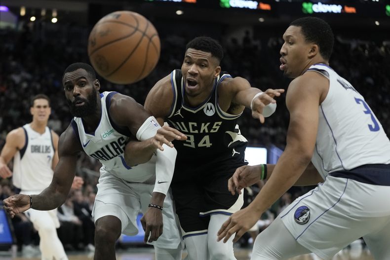 Giannis Antetokounmpo, de los bucks de Milwaukee, persigue un balón entre Grant Williams y Tim Hardaway Jr., de los Mavericks de Dallas, en el duelo del sábado 18 de noviembre de 2023 (AP Foto/Morry Gash)