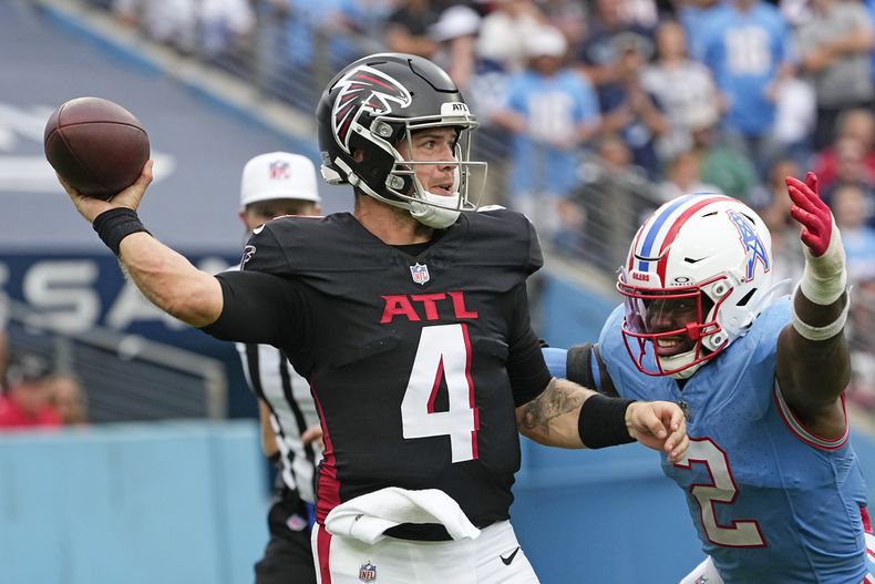 Taylor Heinicke (4), quarterback de los Falcons de Atlanta, lanza bajo la presión del linebacker de los Titans de Tennessee Azeez Al-Shaair (2), durante la segunda mitad del partido de la NFL, el domingo 29 de octubre de 2023, en Nashville, Tennessee. (AP Foto/George Walker IV)