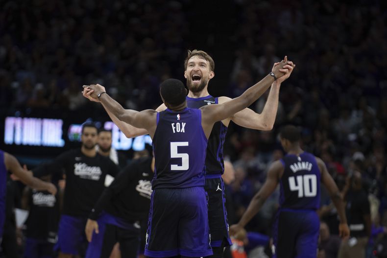 DeAaron Fox, base de los Kings de Sacramento, festeja con el alero Domantas Sabonis durante el encuentro ante los Suns de Phoenix, el viernes 22 de diciembre de 2023 (AP Foto/José Luis Villegas)