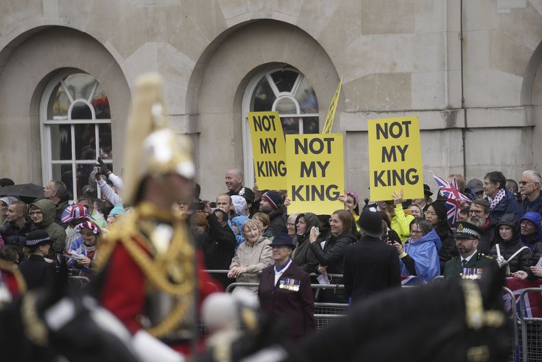 La procesión que acompaña al rey Carlos III y la reina Camila rumbo al Palacio de Buckingham pasa frente a personas que se oponen a la monarquía en Londres, el sábado 6 de mayo de 2023. (AP Foto/Mosaab Elshamy)