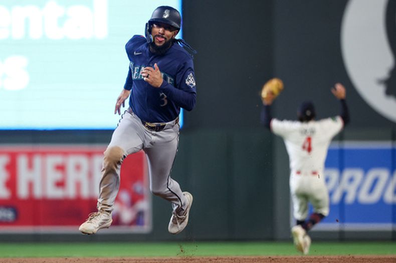J.P. Crawford, de los Marineros de Seattle, avanza a la tercera base tras un doble conectado por Julio Rodríguez durante la octava entrada de un partido de béisbol contra los Mellizos de Minnesota, el martes 28 de abril de 2026, en Minneapolis. (AP Foto/Matt Krohn)