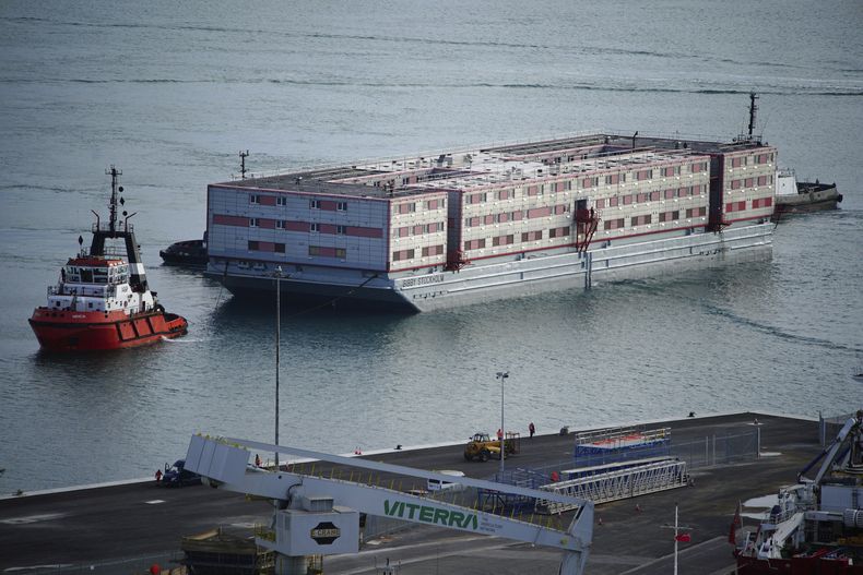 El remolcador Mercia traslada la barcaza Bibby Stockholm hasta el puerto de Portland, en Dorset, donde se utilizará para alojar migrantes tras salir de puerto seco en Falmouth, Cornualles, el martes 18 de julio de 2023. (Ben Birchall/PA via AP)
