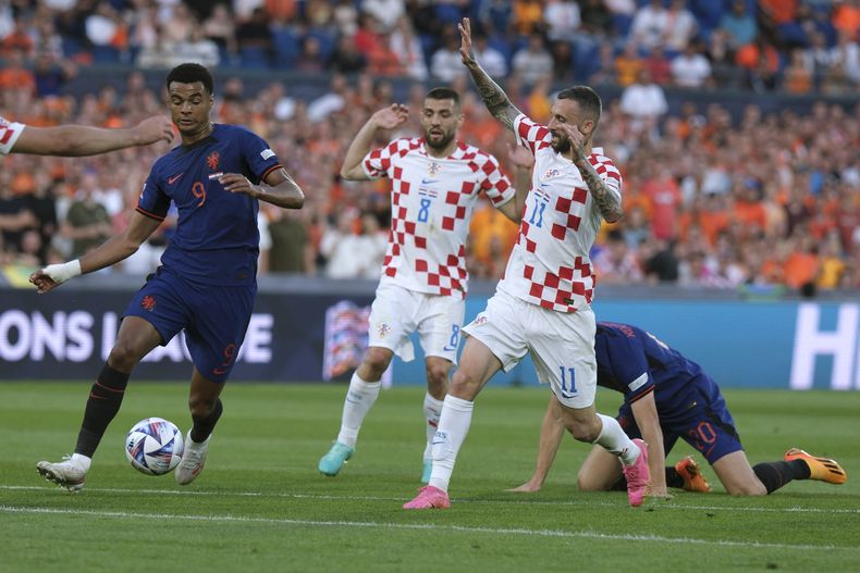 El neerlandés Cody Gakpo (9) pugna un balón con el croata Marcelo Brozovic (11) durante las semifinales de la Liga de Naciones de la UEFA, el miércoles 14 de junio de 2023, en Róterdam, Holanda. (AP Foto/Patrick Post)
