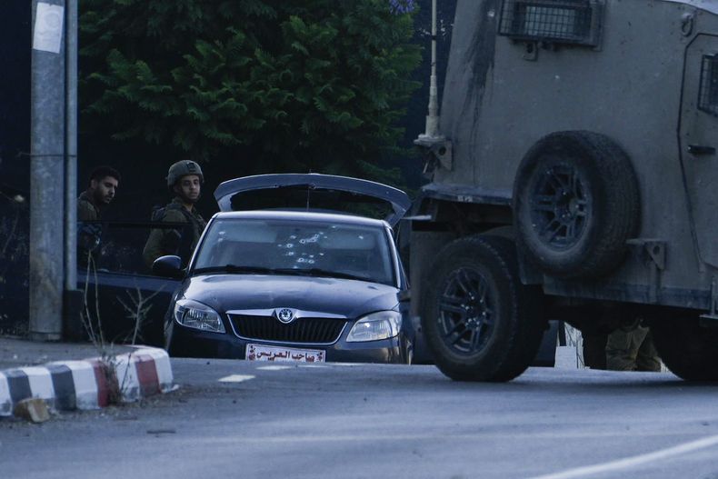 Soldados israelíes, junto a un auto utilizado por tres supuestos pistoleros palestinos que fueron abatidos por las fuerzas israelíes, en Nablus, Cisjordania, el 25 de julio de 2023. (AP Foto/Majdi Mohammed)