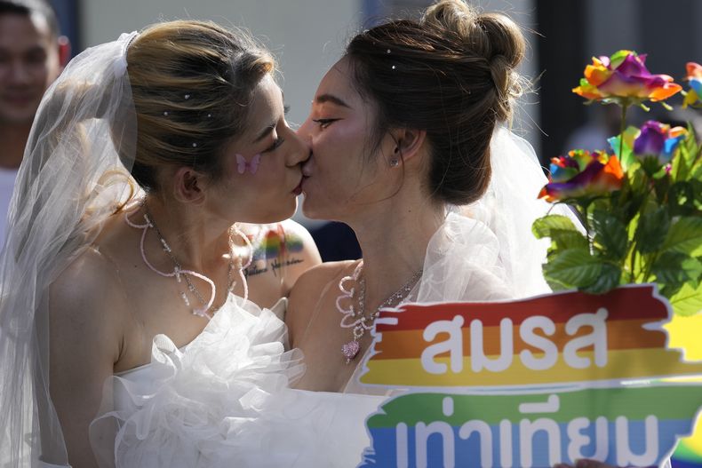 En esta imagen de archivo, dos mujeres se besan mientras sostienen un cartel en favor del matrimonio igualitario, durante un Desfile del Orgullo, en Bangkok, Tailandia, el 4 de junio de 2023. (AP Foto/Sakchai Lalit, archivo)