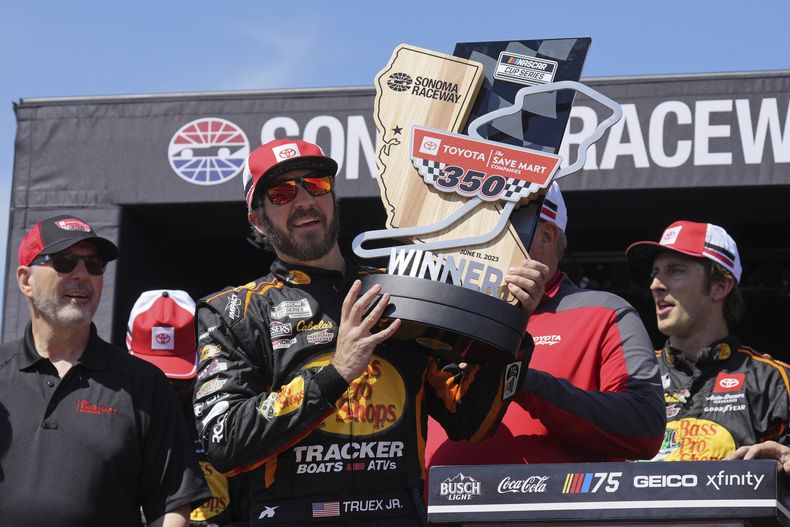 Martin Truex Jr. sostiene el trofeo que lo acredita como ganador de la NASCAR Cup Series en el circuito de Sonoma, el domingo 11 de junio de 2023, en Sonoma, California. (AP Foto/Darren Yamashita)
