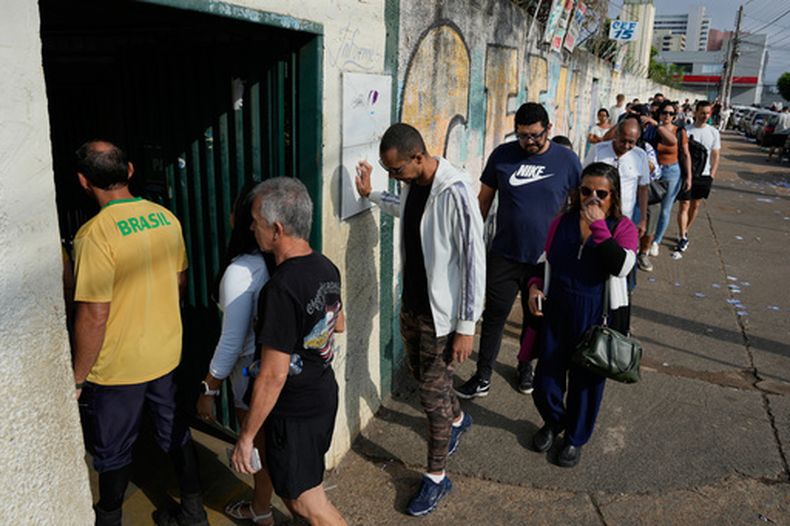 Votantes hacen fila en una casilla electoral durante los comicios generales, el domingo 4 de octubre de 2026, en Brasilia, Brasil. (AP Foto/Eraldo Peres)