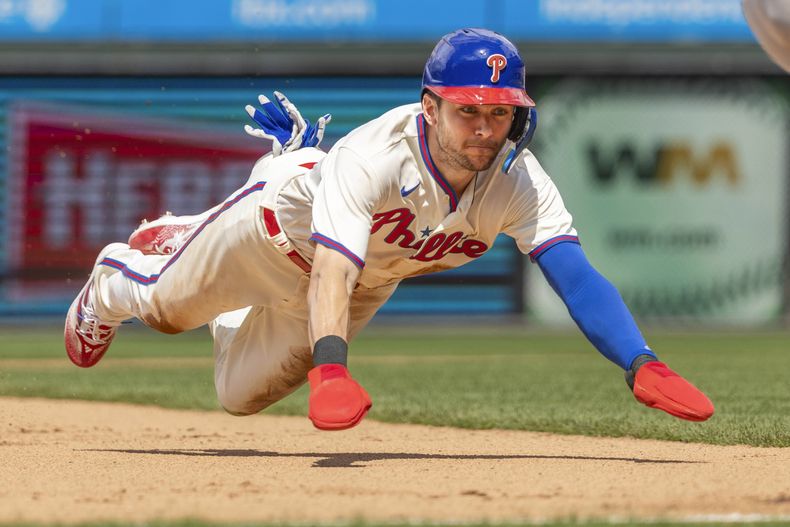 Trea Turner de los Filis de Filadelfia se roba la tercera base camino a anotar con una remolcada de Nick Castellanos en la quinta entrada del encuentro ante los Mets de Nueva York el domingo 25 de junio del 2023. (AP Foto/Laurence Kesterson)