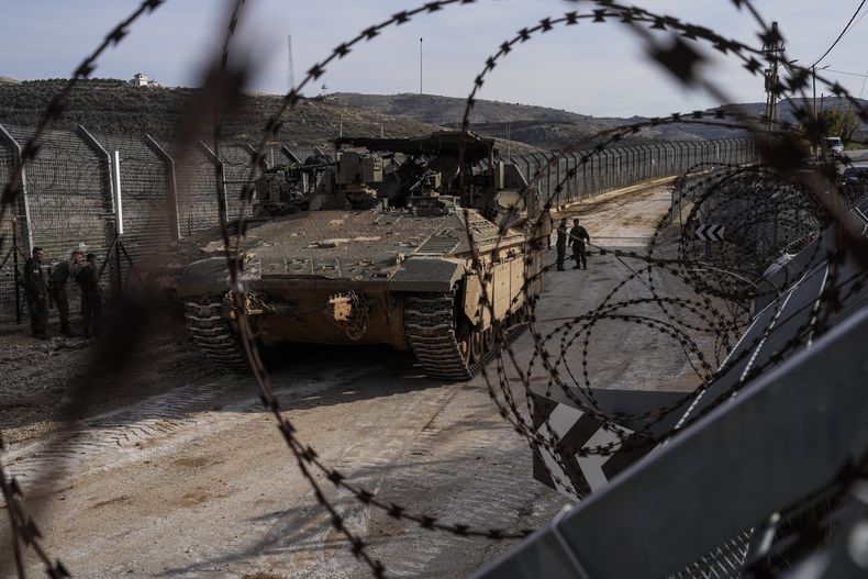 Soldados israelíes junto a vehículos blindados aparcados cerca de la llamada Línea Alfa que separa los Altos del Golán anexionados por Israel de Siria, en la localidad de Majdal Shams, el lunes 9 de diciembre de 2024. (AP foto/Matias Delacroix)
