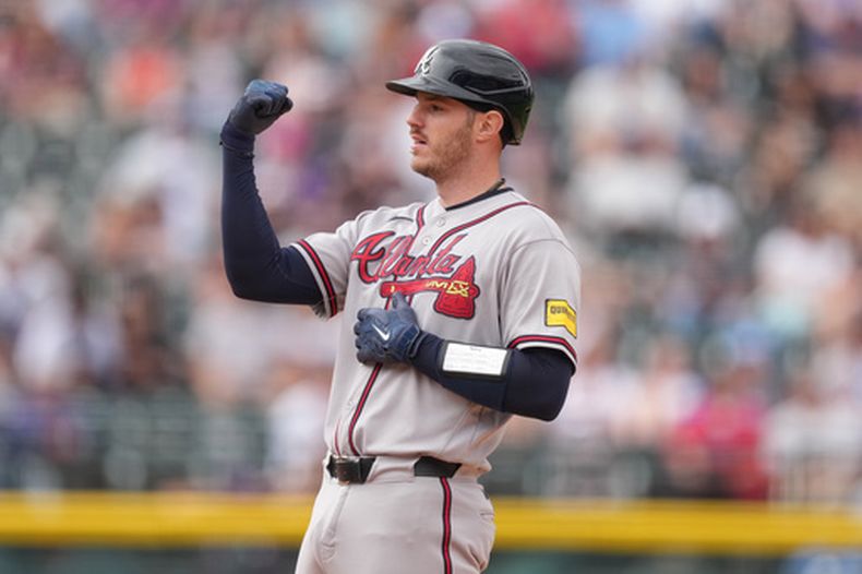 Jonah Heim, de los Bravos de Atlanta, señala hacia el dugout después de llegar a segunda base con un doble frente al relevista de los Rockies de Colorado, Jimmy Herget, que remolcó dos carreras en la novena entrada del juego de béisbol de Grandes Ligas, el domingo 3 de mayo de 2026, en Denver. (AP Foto/David Zalubowski)