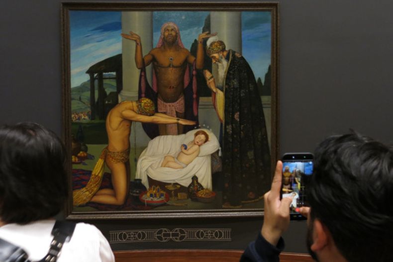 Un miembro de la prensa toma una fotografía de La adoración de los Reyes Magos del pintor mexicano Ángel Zárraga durante una vista previa de la exposición Ángel Zárraga Los Ideales del Arte en la Ciudad de México, el jueves 24 de septiembre de 2026. (Foto AP/Berenice Bautista)