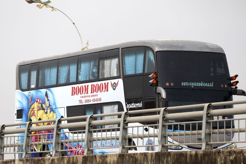 Un autobús, que se cree lleva ciudadanos chinos que trabajaban en centros de estafas en el este de Myanmar, cuza el puente Amistad Tailandia-Myanmar en Mae So en la provincia tailandesa de Tak antes de ser evacuados por avión de regreso a China el jueves 20 de febrero de 2025. (AP Foto/Sarot Meksophawannakul)