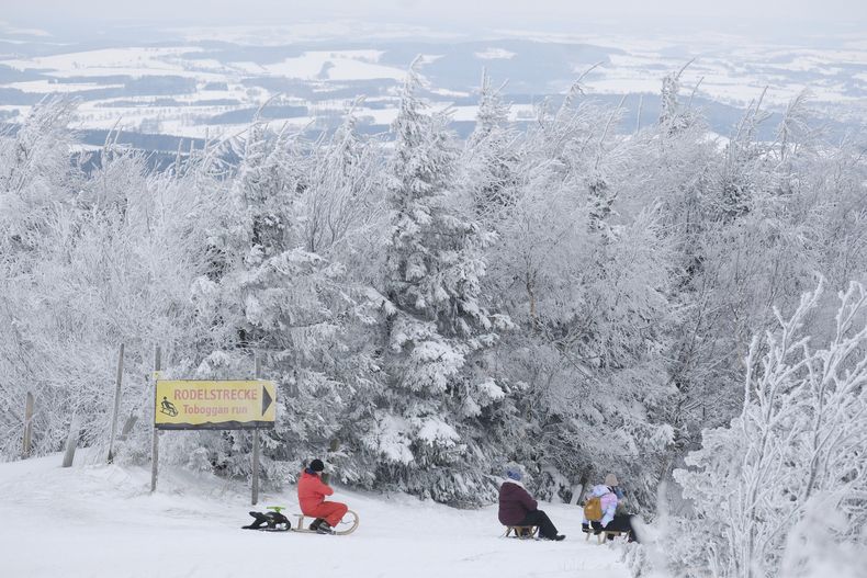 Personas en trineos en la cima del Fichtelberg, Oberwiesentha, Alemania, sábado 4 de enero de 2025. (Sebastian Willnow/dpa via AP)